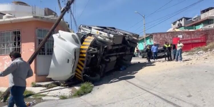 El camión de reparto atravesó un terreno baldío antes de volcarse sobre un automóvil estacionado en la colonia La Madrid, en Saltillo.